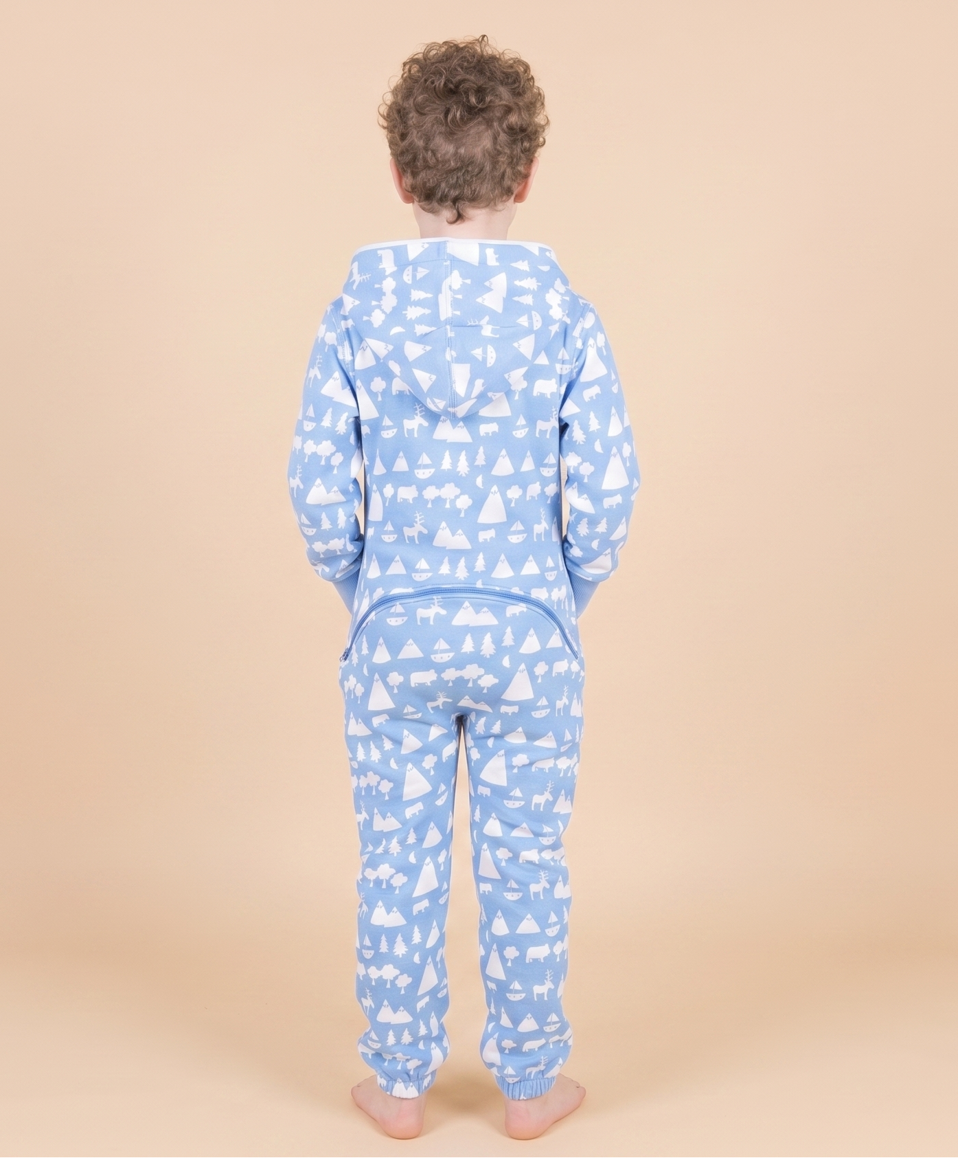 Child wearing blue pajamas with a pattern on a beige background