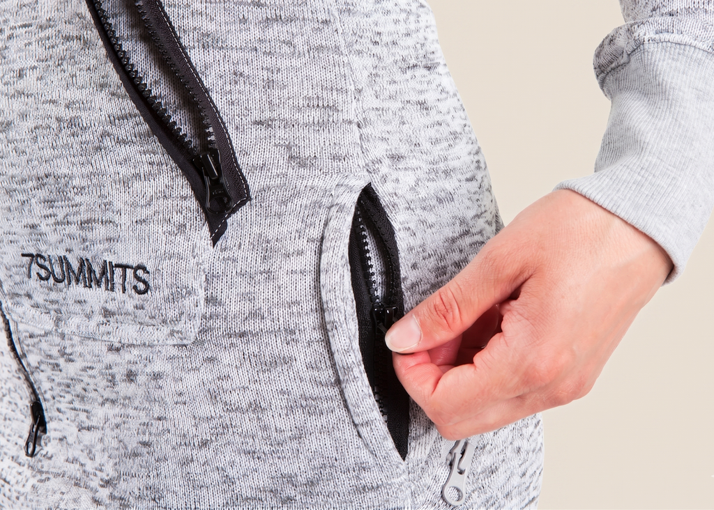 Gray hoodie with black zippers and '7Summits' branding, showing a hand opening a zipper.