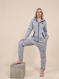 Person wearing a gray onesie with a brand logo on a beige background

