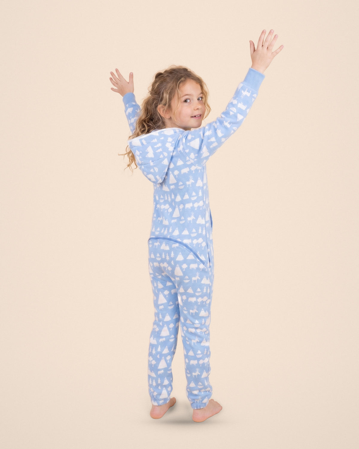 Cloud9 Kids, blue cloud and mountain print kids onesie, Matthew Langille collaboration, playful pose with arms up | Unichill kids onesie designed in Calgary