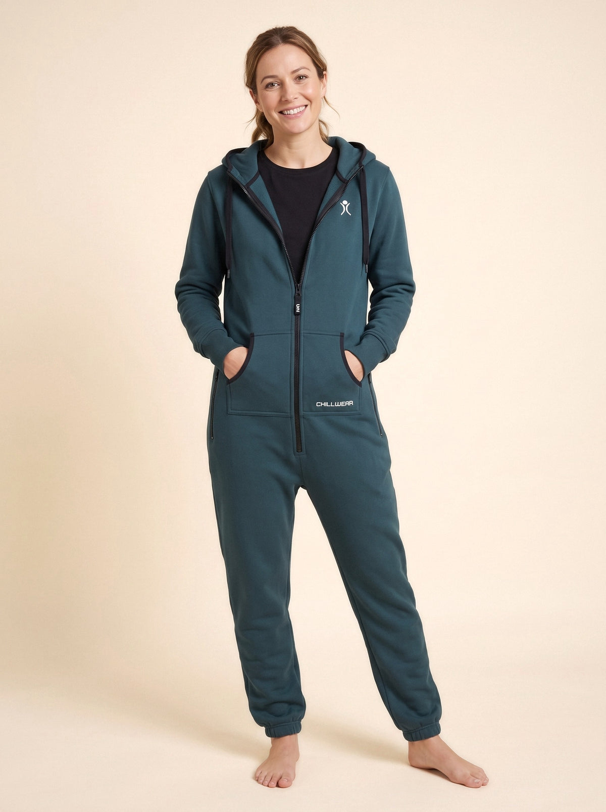 Transformative Teal onesie on a woman, front view on a beige background | Unichill adult unisex fleece onesie designed in Calgary